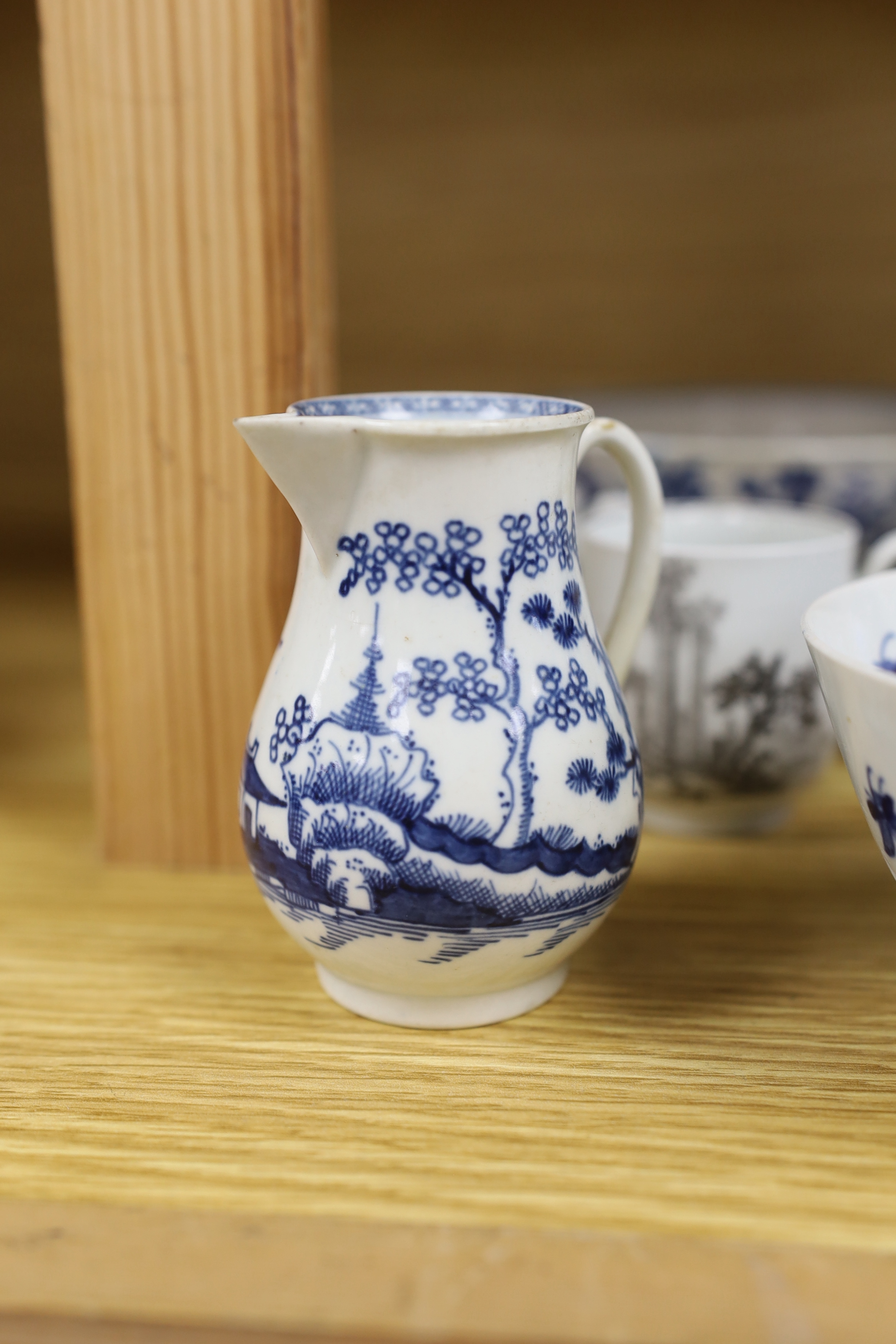 18th century Worcester comprising two floral bowls, two jugs, and three transfer printed cups, the largest 15cm in diameter (7)